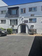 View of front of house with uncovered parking and a balcony