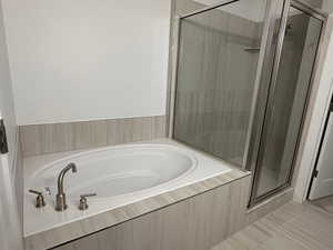 Bathroom featuring a stall shower and a bath