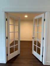 Hallway with dark wood-style floors, recessed lighting, and french doors