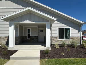 Entrance to property featuring covered porch and stone siding