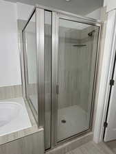 Full bathroom featuring a shower stall and a garden tub