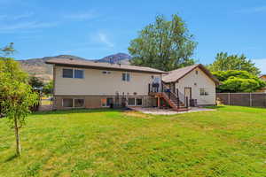 Back of house with stairs, a fenced backyard, a mountain view, and a patio