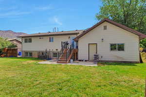 Back of property featuring stairs, a mountain view, and a patio area