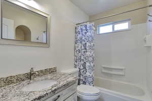 Bathroom with shower / bath combination with curtain and vanity