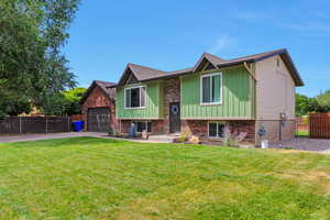 Bi-level home with driveway, board and batten siding, and roof with shingles