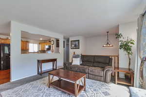 Carpeted living area with baseboards and a textured ceiling