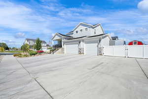 Corner lot view of home with 3 car attached garage and RV parking with vinyl fencing and gates