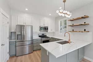 Kitchen featuring stainless steel appliances, white cabinets, gray cabinets, backsplash, and recessed lighting
