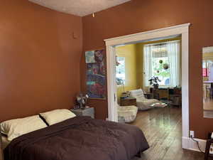 Bedroom with hardwood / wood-style floors and a textured ceiling