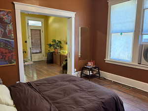 Bedroom with hardwood / wood-style flooring and baseboards