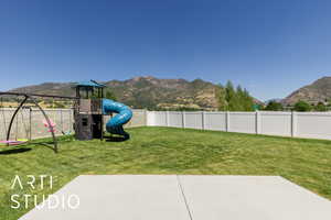 Fenced backyard with a mountain view and a playground