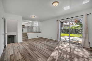 Unfurnished living room featuring light wood-type flooring and baseboards