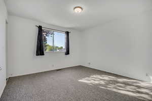 Spare room with carpet and baseboards