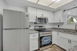 Kitchen featuring stainless steel appliances and white cabinets