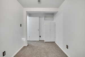 Carpeted spare room with baseboards
