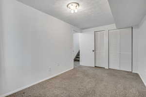 Unfurnished bedroom with carpet floors and two closets