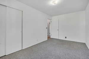 Unfurnished bedroom featuring carpet and a closet