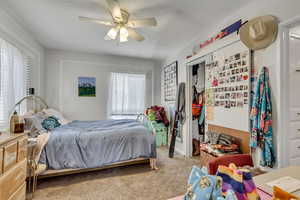 Unit A bedroom featuring carpet flooring and ceiling fan.