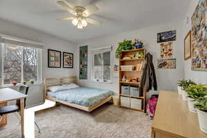 Unit A bedroom with light carpet, multiple windows, and a ceiling fan.