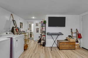 Unit B laundry room featuring light lvp finished floors and washing machine and clothes dryer.