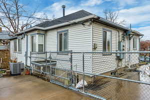 View of side of home featuring a shingled roof and a central AC unit.