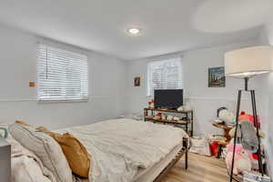 Unit B bedroom featuring wainscoting and lvp finished floors.
