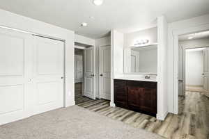 Unfurnished bedroom featuring a textured ceiling, light wood-style flooring, connected bathroom, a closet, and recessed lighting