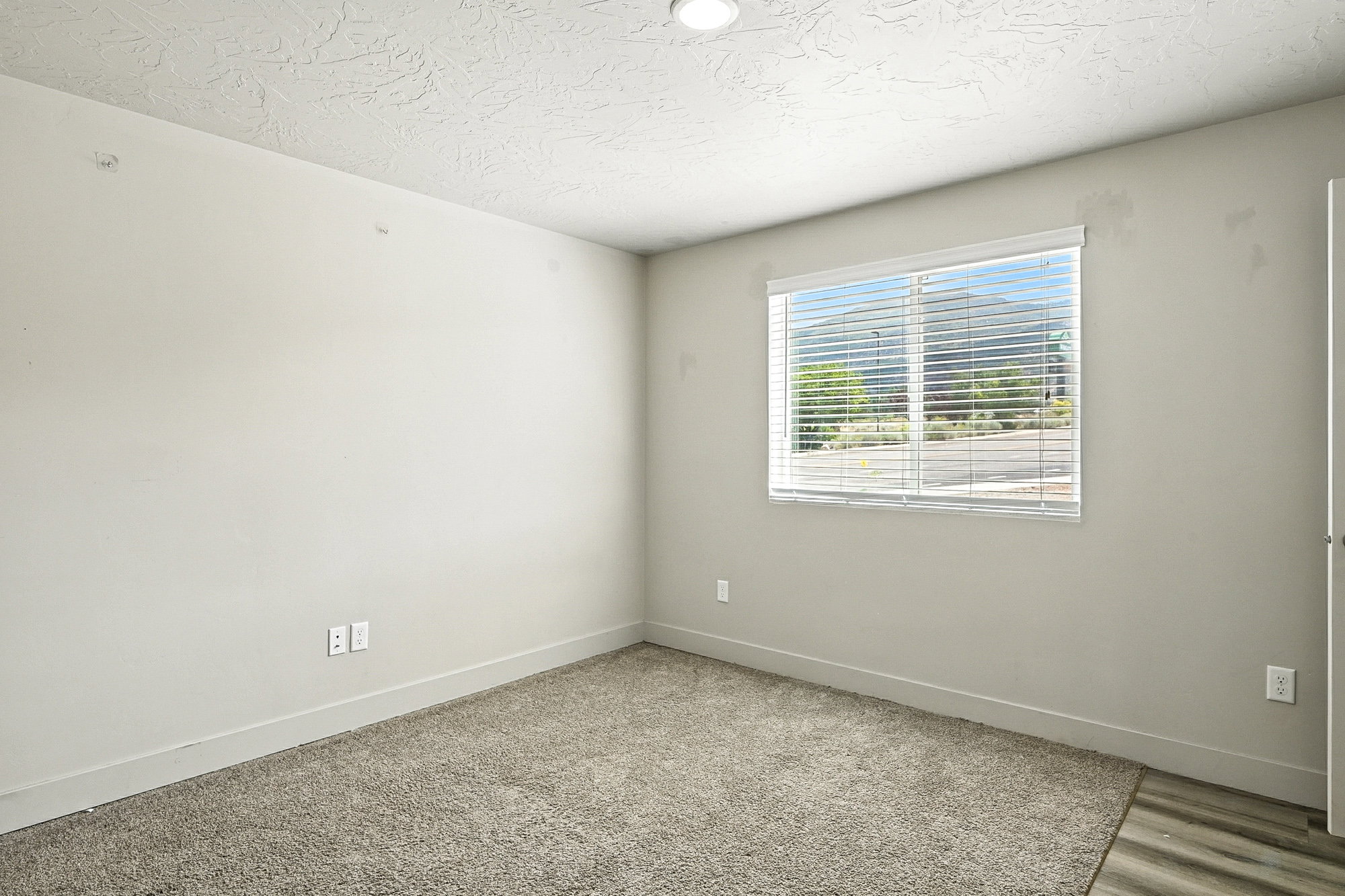 Unfurnished room featuring a textured ceiling and baseboards