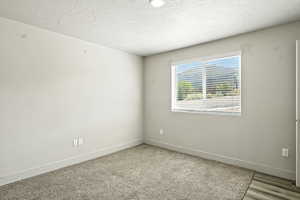 Unfurnished room featuring a textured ceiling and baseboards