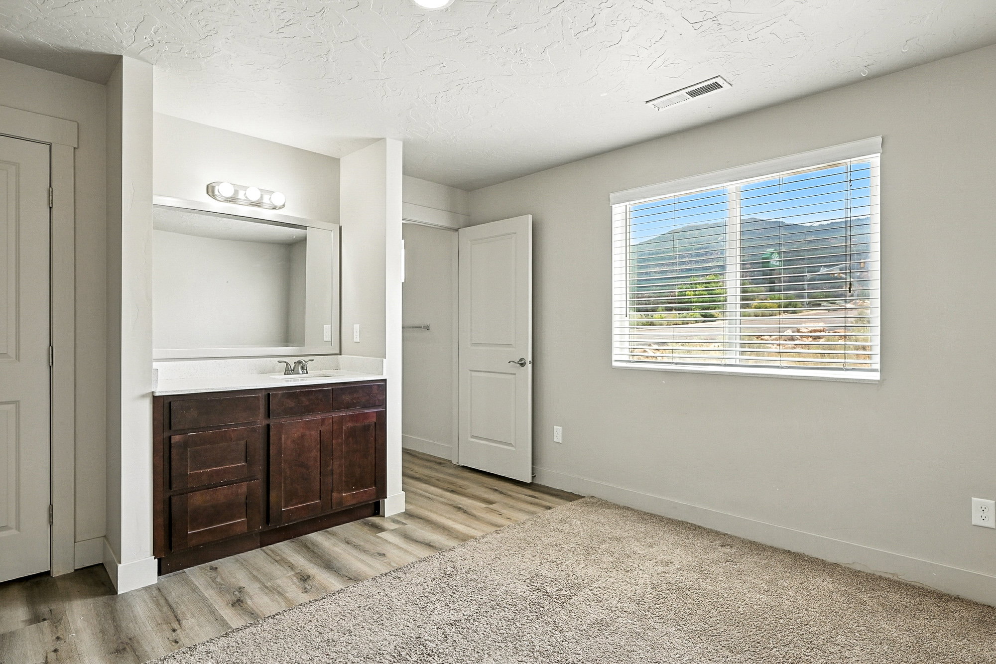 Bathroom featuring vanity, a textured ceiling, and light wood-style flooring