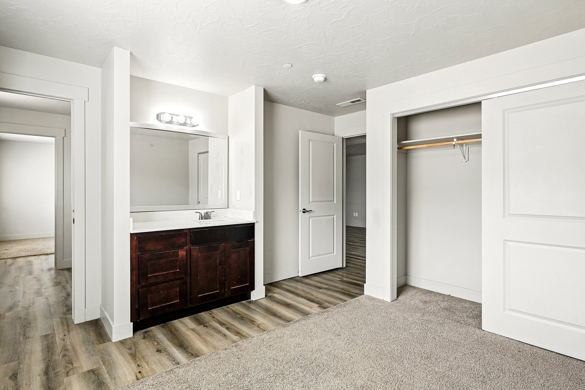 Bathroom with vanity, a textured ceiling, and light wood finished floors