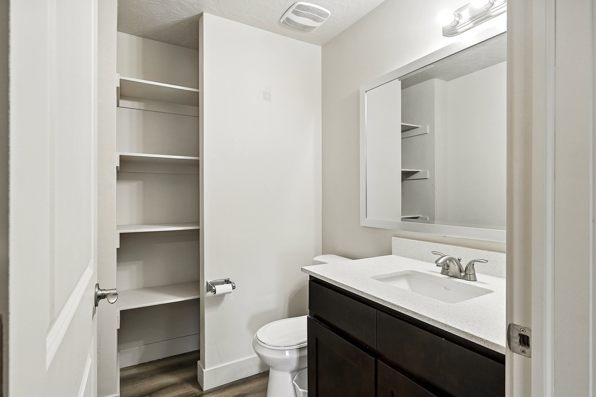 Bathroom with vanity, dark wood-style floors, a textured ceiling, and a closet