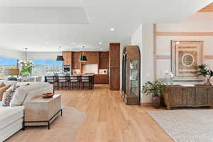 Living area with light wood-style floors and recessed lighting