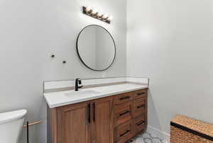 Half bathroom featuring vanity and toilet