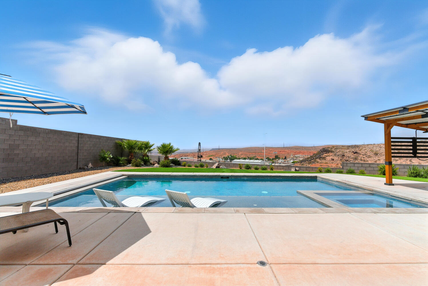 View of swimming pool featuring a patio area, a pool with connected hot tub, and a fenced backyard