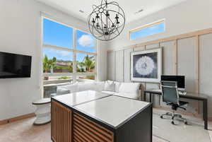Office area featuring baseboards and a chandelier