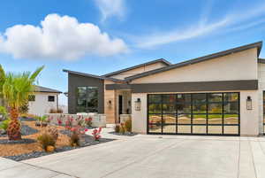 Contemporary house featuring driveway, a garage, and stucco siding