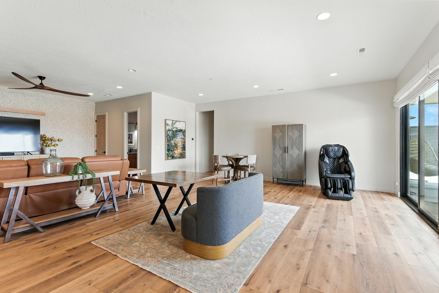 Living room with light wood-type flooring, recessed lighting, ceiling fan, and wallpapered walls