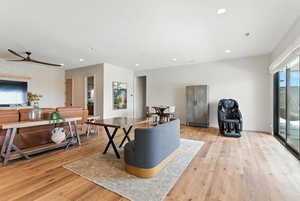 Living room with light wood-type flooring, recessed lighting, ceiling fan, and wallpapered walls