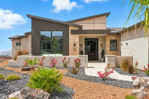 Entrance to property with stucco siding and stone siding