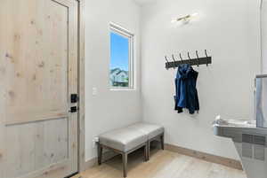 Mudroom featuring light wood-style floors and baseboards