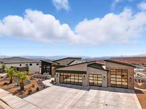 Modern home with an attached garage, driveway, and a mountain view