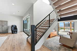 Staircase with wood-type flooring and recessed lighting