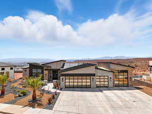 Contemporary house with a garage, driveway, a mountain view, and stucco siding