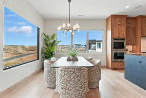 Dining space featuring light wood finished floors, a chandelier, and recessed lighting