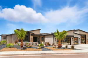 Contemporary home with a standing seam roof, a metal roof, concrete driveway, and stucco siding