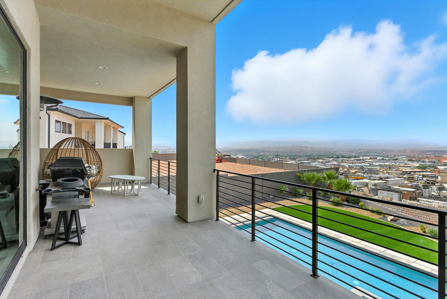 Balcony with view of pool area and a grill