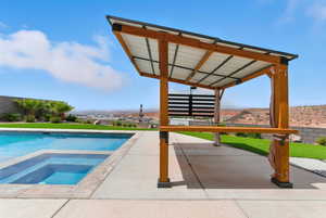 Outdoor pool with an in-ground hot tub, a patio area, and a lawn
