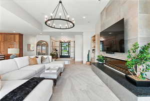 Living area with recessed lighting, a chandelier, and a glass covered fireplace