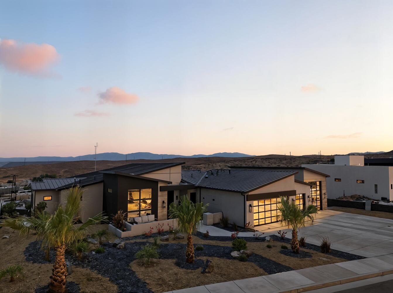 View of front of house with a garage, stucco siding, concrete driveway, a metal roof, and a standing seam roof
